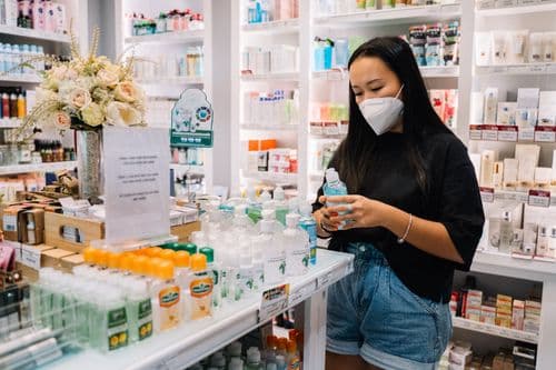 A customer exploring products on pharmacy shelves
